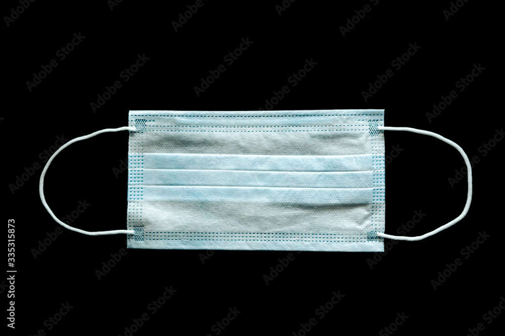White medical disposable mask on a black background White medical disposable mask on a black background
