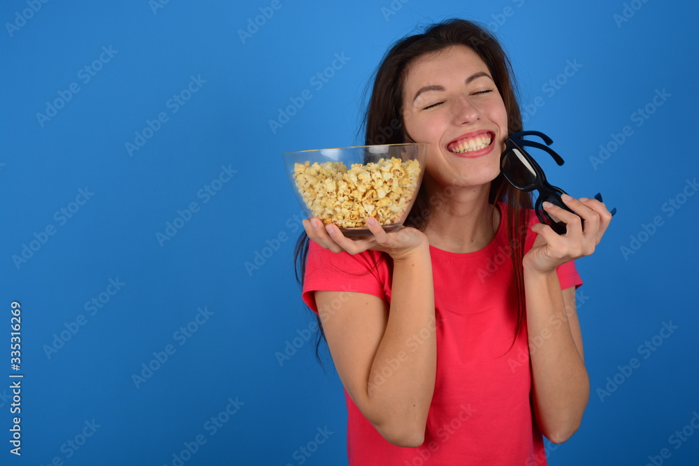 joyful woman with popcorn on a blue cinema background joyful woman with popcorn on a blue cinema background