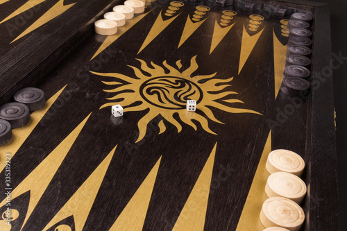 Backgammon. Board game. White cubes and chips on a blackboard.  Dice on backgammon board game. Selective focus. Playing leisure games photo