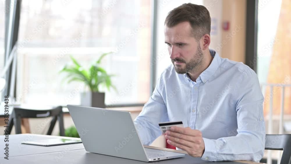 Online Payment Success by Young Man on Laptop in Office Online Payment Success by Young Man on Laptop in Office
