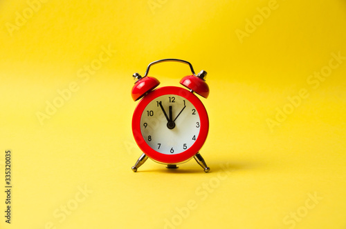 Vintage alarm clock red on a yellow background