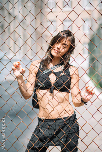 beautiful athletic woman in black clothes on the playground behind bars. Quarantine, self-isolation. Healthy lifestyle. Soft selective focus. © Tasha Sinchuk