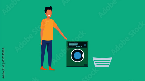 Boy standing by a washing machine and a basket.