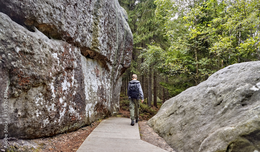 Rear view of a tourist visiting Errant Rocks (Błędne Skały)- rocks formed by erosion located in the Table Mountains National Park, Poland Rear view of a tourist visiting Errant Rocks (Błędne Skały)- rocks formed by erosion located in the Table Mountains National Park, Poland