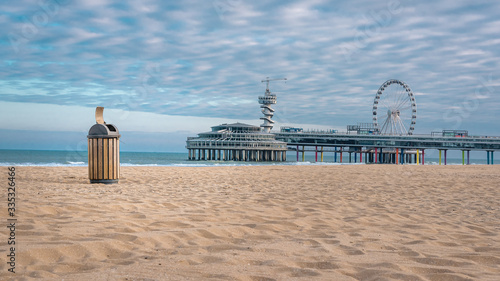 Beach of Scheveningen with a beautiful cloud cover and an empty trash can. Still life by carona virus photo