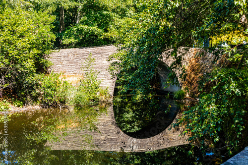 Stone bridge refelcted in a pond. Hamilton Gardens, Hamilton, New Zealand