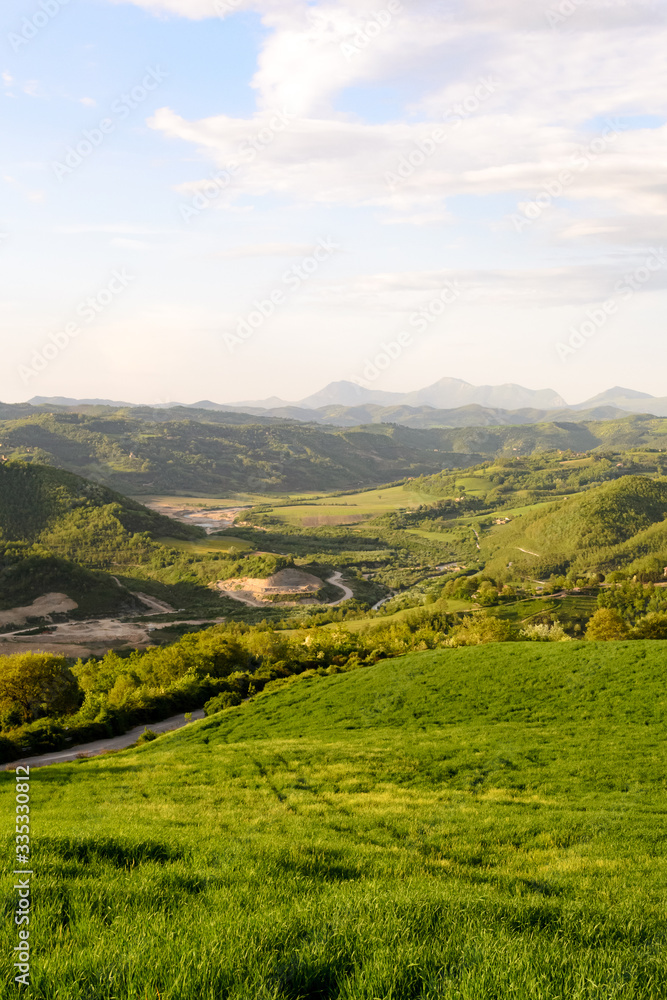 Fototapeta premium Amazing green landscape in central Italy, in Umbria between Gubbio and Assisi. Here the land is highly cultivated and there are a lot of beautiful old trees and many footpaths to walk in the nature