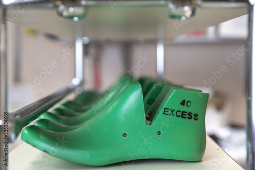 Green shoe lasts in a row on shelf in foot wear factory photo