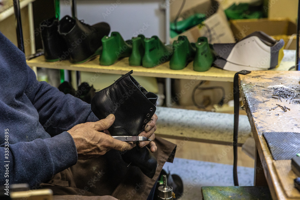 Craftman shoemaker working with leather shoe on lasts in manufacture Craftman shoemaker working with leather shoe on lasts in manufacture