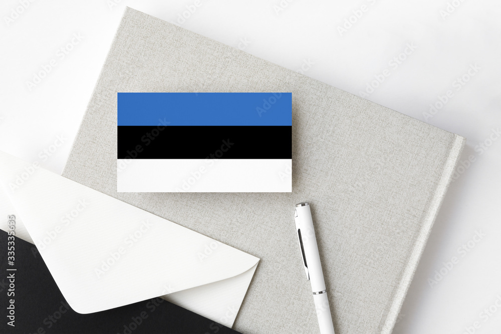 Estonia flag on minimalist letter background. National invitation envelope with white pen and notebook. Communication concept. Estonia flag on minimalist letter background. National invitation envelope with white pen and notebook. Communication concept.