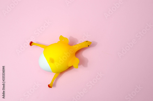 Chicken eggs and toy chicken on pink background. Easter concept. Top view