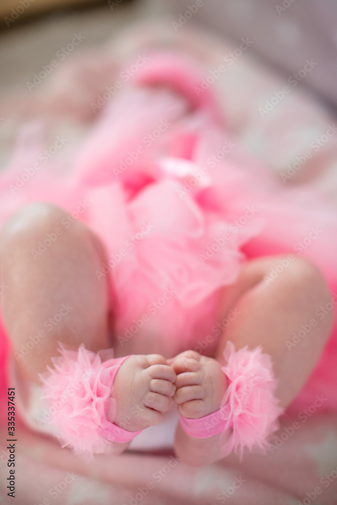 legs of a little baby girl in a pink skirt legs of a little baby girl in a pink skirt