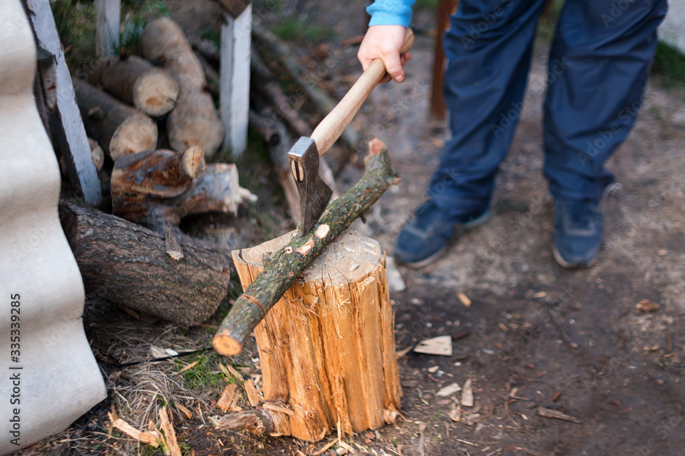 Obraz premium Man chopping wood in the backyard. Lumberjack cuts logs