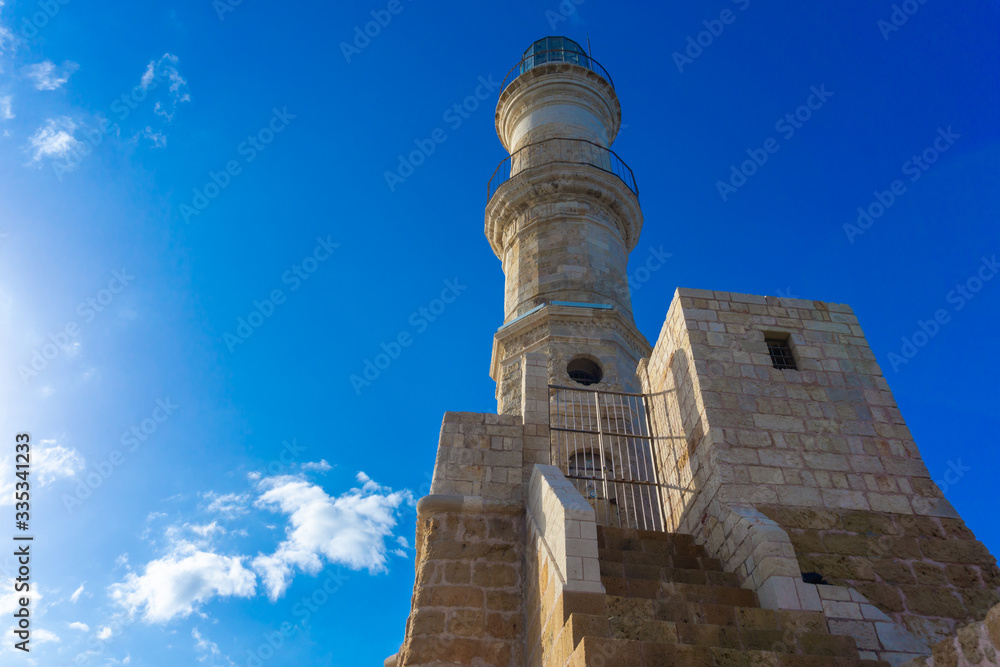 Ancient venetian lighthouse in mediterranean region against bright blue sky.