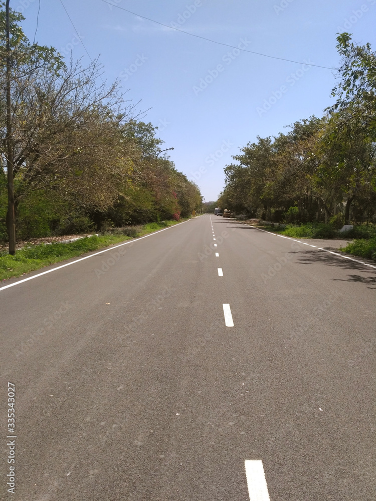 Obraz premium Deserted road in Omega 2 sector in Greater Noida, Uttar Pradesh, India due to lockdown. Lockdown because of coronavirus