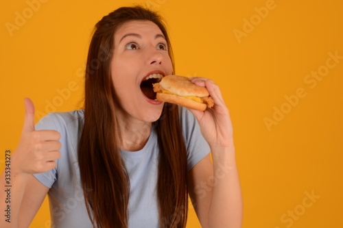 woman in t-shirt holding fast food burger in her hands