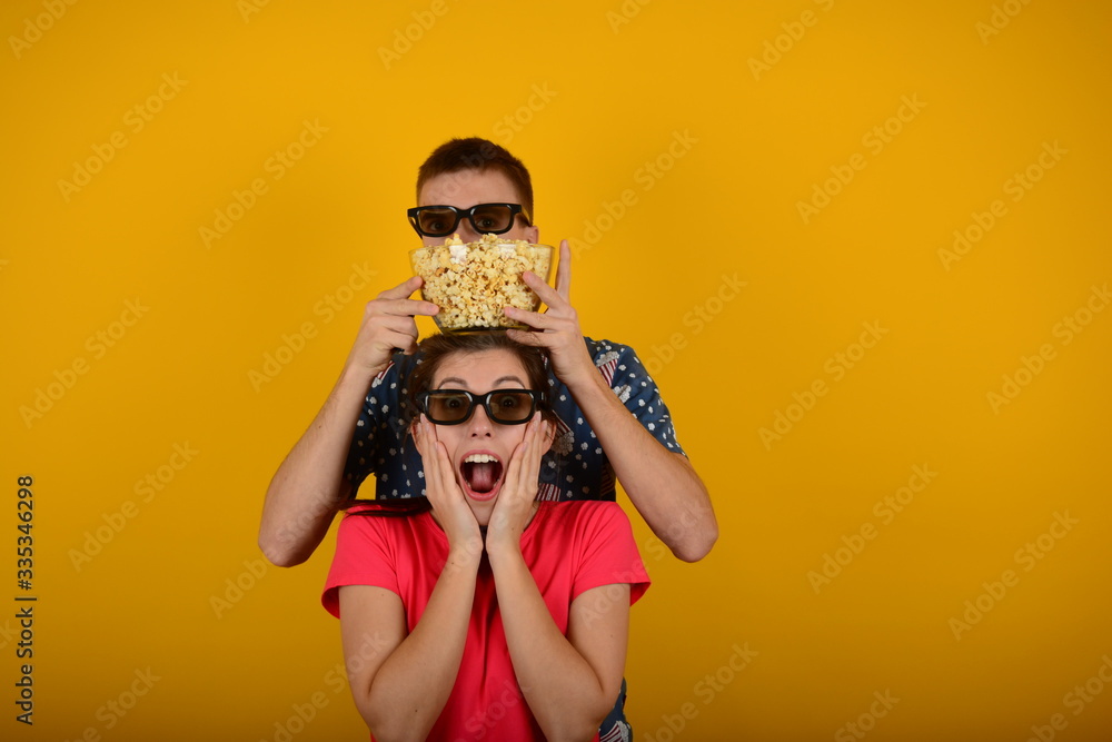 Fototapeta premium young couple in 3D glasses with popcorn in their hands