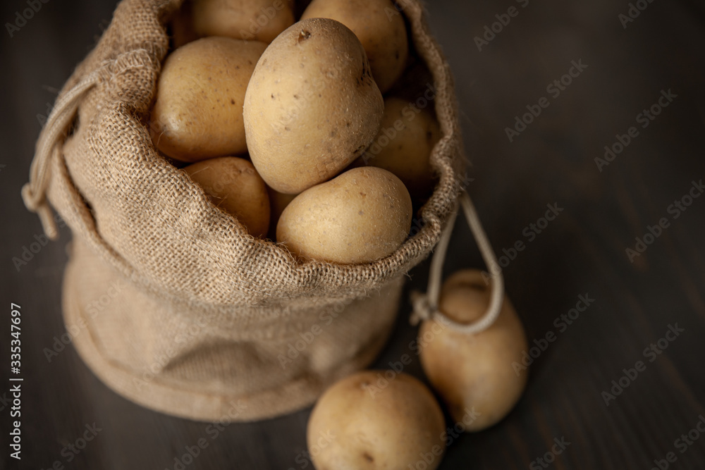 Potatoes in sackcloth on rustic wooden background Potatoes in sackcloth on rustic wooden background