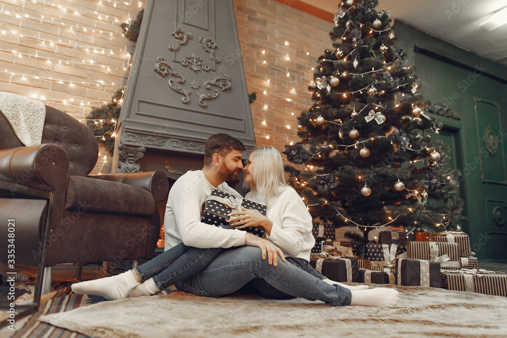 Obraz premium Lady in a white sweater. Family sitting on a floor. Couple near christmas tree.