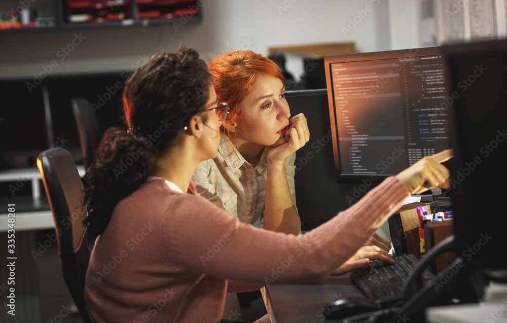 Two female programmers working on new project.They working late at night at the office.
Two female programmers working on new project.They working late at night at the office.
