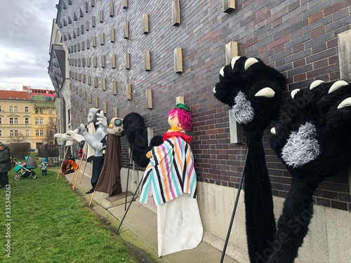 Photography giant puppets leaning against the side of a church