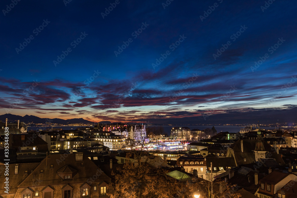 Vue nocturne de Lausanne depuis la Place de la Cathédrale au coucher du soleil (Suisse)