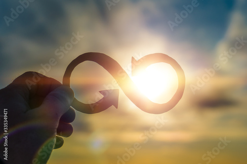 Infinity symbol in hand on a sunset background. Business concept idea, creative.