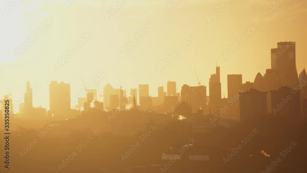 A polluted, bright, hazy morning sunrise in London with bright chimney smoke. A polluted, bright, hazy morning sunrise in London with bright chimney smoke.