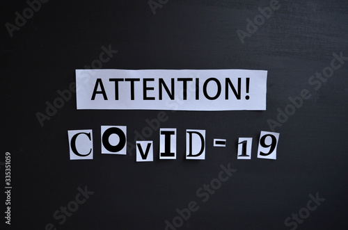 the inscription "attention COVID-19" on a black background