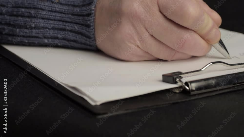 Busy person writing up notes on a clipboard close up Busy person writing up notes on a clipboard close up