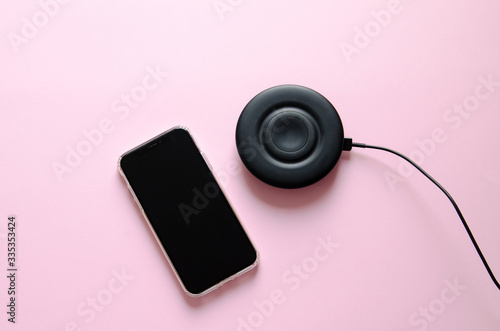 Smartphone with wireless charge on pink background