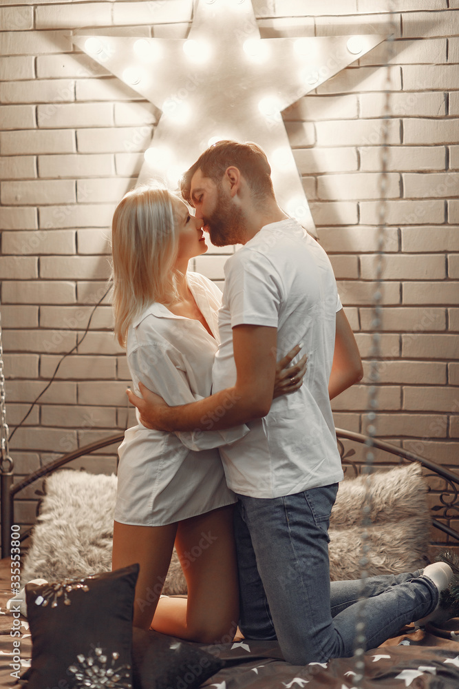 Cute couple in a bedroom. Lady in a white shirt. Pair at home Cute couple in a bedroom. Lady in a white shirt. Pair at home