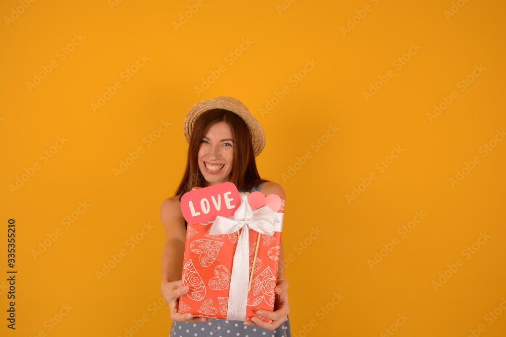 happy joyful woman with gift on yellow party background