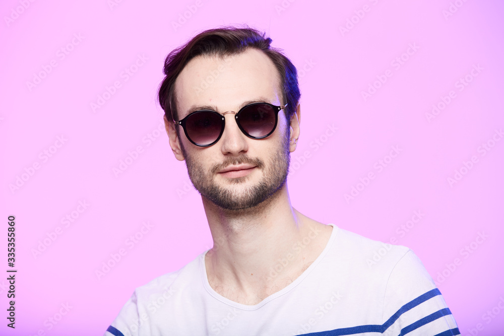 Studio shot of handsome man wearing sunglasses over pink background. Studio shot of handsome man wearing sunglasses over pink background.