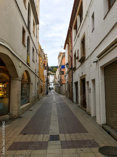 Staight spanish street with modern stone pavement and storehouses © Mate