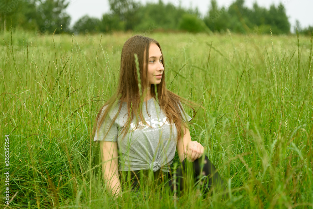 Girl sitting in the grass in the meadow Girl sitting in the grass in the meadow