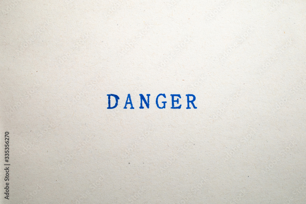 Φωτογραφία a DANGER word stamped on a piece of paper.