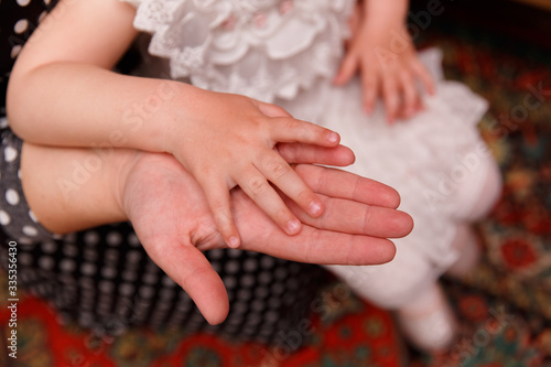 Mom’s hand holds daughter’s hand