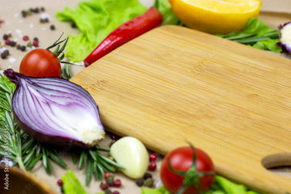 Brown wooden cutting board with summer vegetables and champignon mushroom on table background. Brown wooden cutting board with summer vegetables and champignon mushroom on table background.
