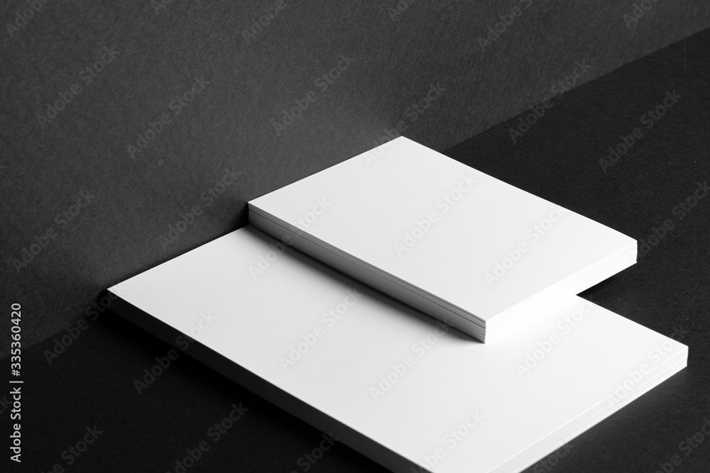 Stacked white businesscards for branding identity on black background, copy space Stacked white businesscards for branding identity on black background, copy space