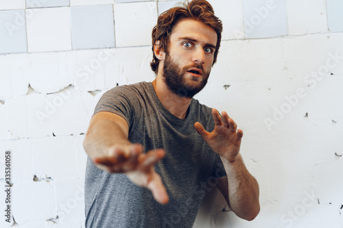 Portrait of Expressive young  bearded man scared and nervous photo