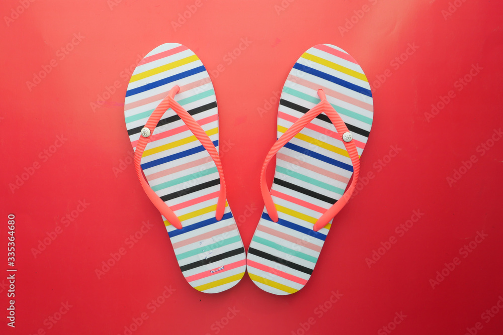 Female beige sandals on red background , top view.