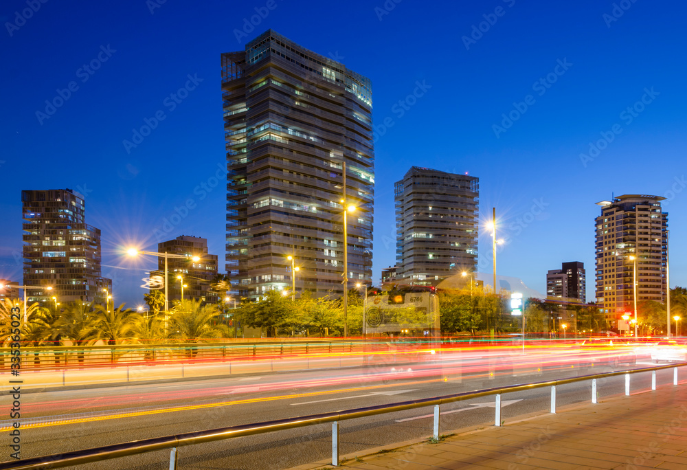 Paisaje urbano de los edificios de la ciudad de Barcelona al anochecer con calle en primer termino y las luces de los coches. Paisaje urbano de los edificios de la ciudad de Barcelona al anochecer con calle en primer termino y las luces de los coches.