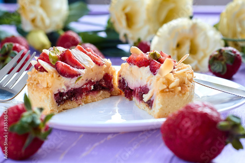Сut of mini tart cupcake with strawberries on plate. Close up.