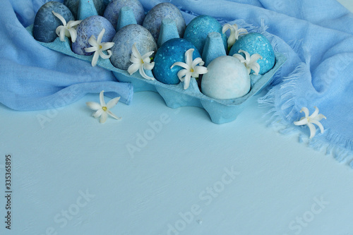 Easter background with blue eggs and spring flowers. Happy Easter Spring Festive greeting card. Holidays Naturally Eggs painted with hibiscus with marble stone effect. copy space