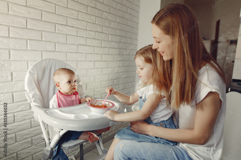 Baby eating. Mother feeds the baby. Little child in a kid's chair. Baby eating. Mother feeds the baby. Little child in a kid's chair.