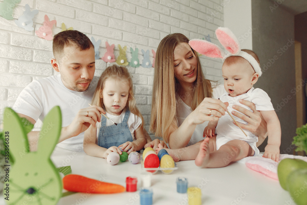 Parents and daughter paint eggs. Family in a kitchen. Preparing for Easter Parents and daughter paint eggs. Family in a kitchen. Preparing for Easter
