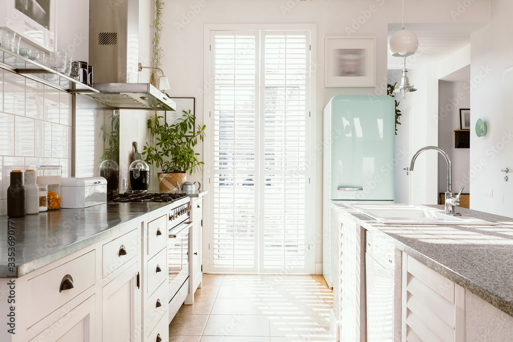 Bright kitchen interior with modern white furniture pastel mint fridge and big floor to ceiling window Stock Foto Adobe Stock