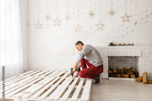 Construction of bed. The man puts the bed frame.