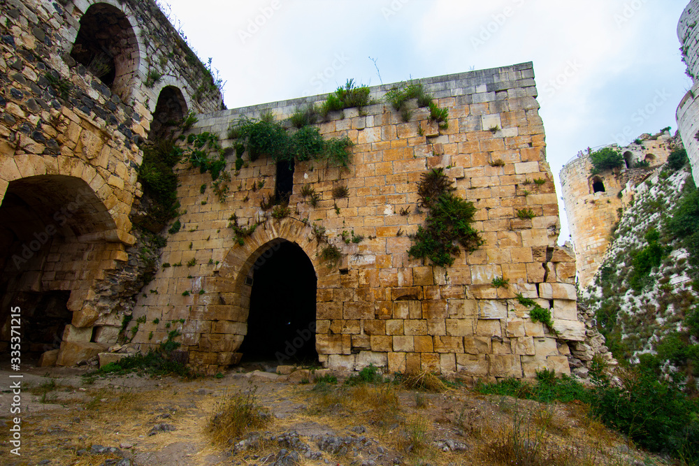 Krak (Crac) des Chevaliers, also called (‎Castle of the Kurds), and formerly Crac de l'Ospital, is a Crusader castle in Syria and one of the most important preserved medieval castles in the world. - obrazy, fototapety, plakaty 